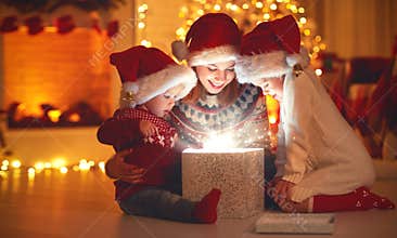 Merry Christmas! family mother and children with magic gift at