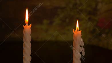 Two big burning candles. Bright light on dark background. Darkness template. Birthday party. Romantic evening on