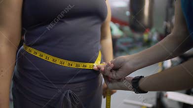 Fitness trainer measuring female belly, healthy diet and workout results control