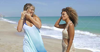 Stylish women walking on beach