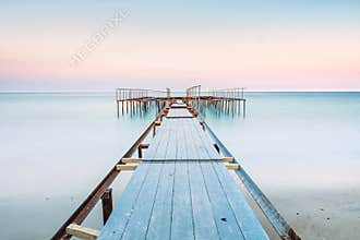 Long esposure view of a old jetty in a calm sea with gentle sky, soft colors