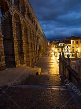 Segovia, Spain at the ancient Roman aqueduct. The Aqueduct of Segovia, located in Plaza del Azoguejo, is the defining historical f