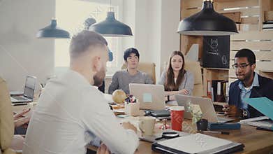 Serious employees talk to unrecognisable female boss at meeting. Office workers talk to CEO at loft modern office 4K.