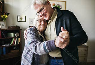 Senior couple dancing together at home
