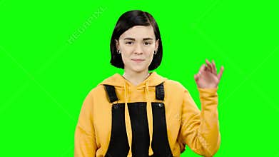 Teenager advertises a product and shows okay. Green screen