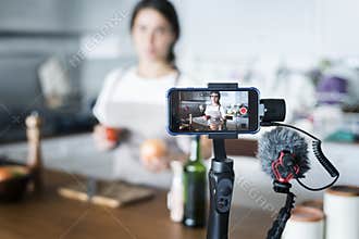 Female blogger recording cooking related broadcast at home