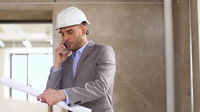 Architect with blueprint calling on smartphone