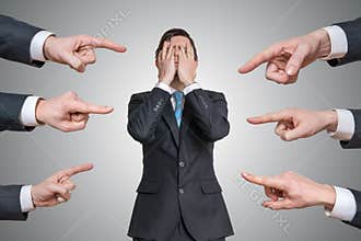 Many hands are pointing on guilty man and blame him