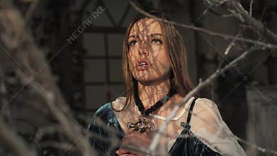 Close up portrait of young nun. Nun is praying. Beautiful woman in old fashioned dress and big gold cross