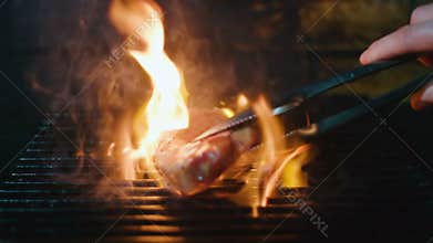 Put Meat on Grill. Slow Motion Shot of Cooking Steak on Grill.