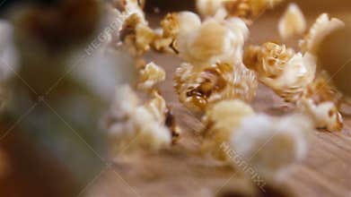 Popcorn falling on authentic wooden table - super slow motion shot