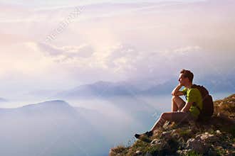 Man sitting on top of mountain, achievement or opportunity concept, hiker