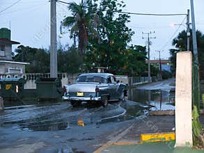 Old Cuban car crossing a puddle.