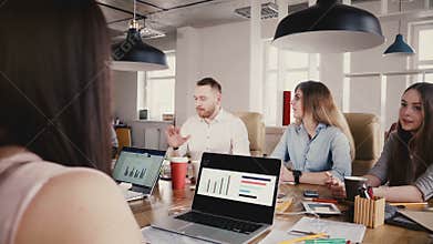 Employee talks to unrecognisable boss at the table. Office workers talk to CEO at modern office meeting, panning shot 4K