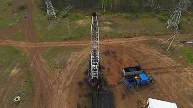 Company Employees Work on Oil Rig against Forest