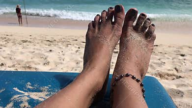 Woman feet on a beach chair on the paradise tropical beach of Bali island, Indonesia.