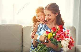 Happy mother`s day! child daughter gives mother a bouquet of f
