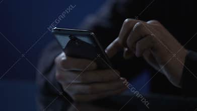 Man typing message on smartphone, wasting time at night party, hands closeup