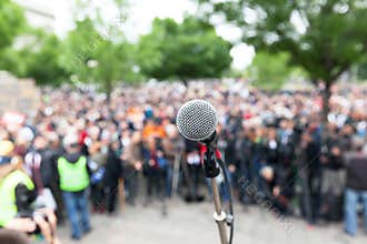 Political protest. Demonstration. Microphone in focus against bl