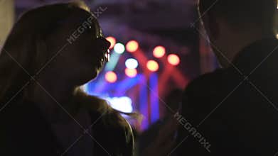 Young woman intoxicated by drugs or alcohol dancing to man at night club party