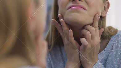 Girl observing blackheads on chin, frustrated with acne, problem skin in puberty