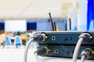 Close up Jack plug cables connected with old box of wireless microphone in conference meeting room seminar business blur