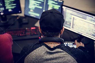 Caucasian tattooed man working on coding