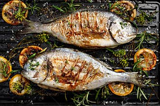 Grilled bream fish, dorada fish with the addition of spices, herbs and lemon on the grill barbecue