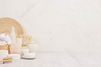 Natural spa white cosmetics products and beige bamboo rustic decor on white wood background, interior, border.