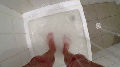 The feet of a man in the shower