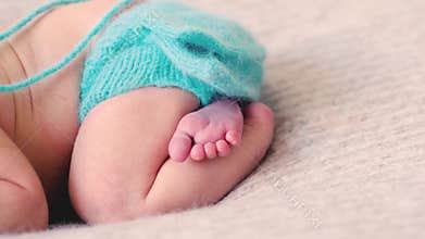 Adorable sleeping baby in blue knitted clothes