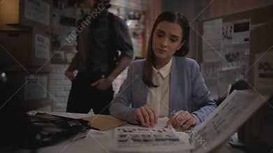 Lady detective checking criminal fingerprints database, examining evidence