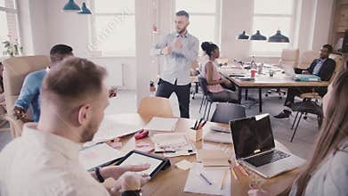 Cheerful European young CEO celebrating success with fun dance in modern office, making colleagues join in, slow motion.