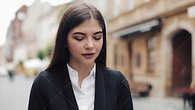 Young businesswoman using mobile phone near business center. Woman using mobile phone for business communication voice