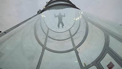 Man skydiver fly into wind tunnel up and down. Flying in a skydiving tunnel