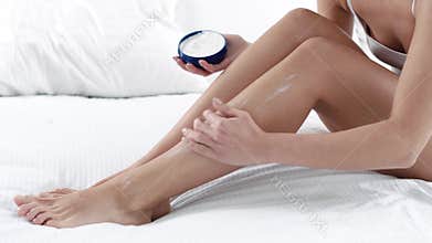 Body Skin Care. Woman Applying Body Cream On Leg Skin At Bedroom