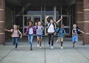 Group school school kids running as they leave the school building