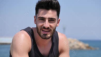 Young man sitting on a beach alone and lonely