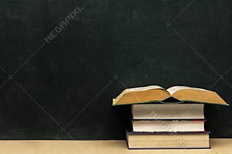 Four books stacked, the topmost book opened.