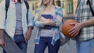 Popular college girl standing between two guys, choosing date, affection