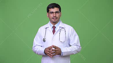 Young handsome Persian man doctor showing something