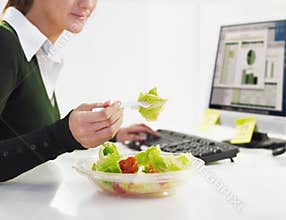 Businesswoman eating salad