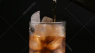 Glass cup with ice and drink on black background