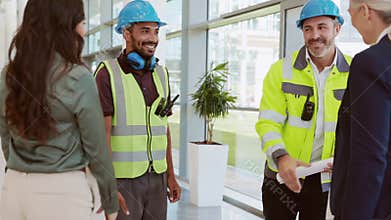 Manual workers and architects meeting at construction site