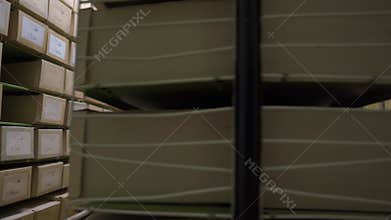 Rows of metal racks with archive boxes lying on shelves
