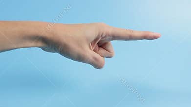 Woman hand with the index finger pointing to the side close-up on a blue background. Advertising concept, announcements