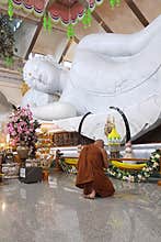 Buddhist monk pay respect to white marbleÂ  reclining Buddha statueÂ  atÂ WatÂ Pa Phu Kon . Photo taken  in Udorn Thani Thailand