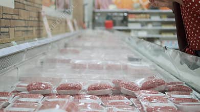 Closeup of Senior Woman Buying Meat in a Store