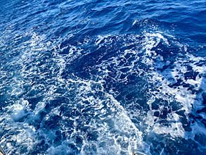 Seething ice waves of the northern ocean. Translucent blue-turquoise water with sea foam backlit by the sun. Transparent.