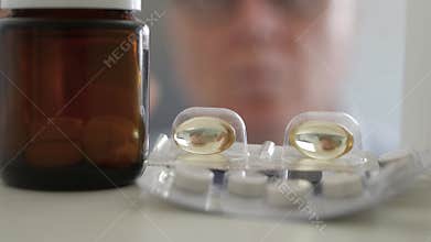Older Man Opening a Medicine Cabinet and Choosing Few Medical Pills.